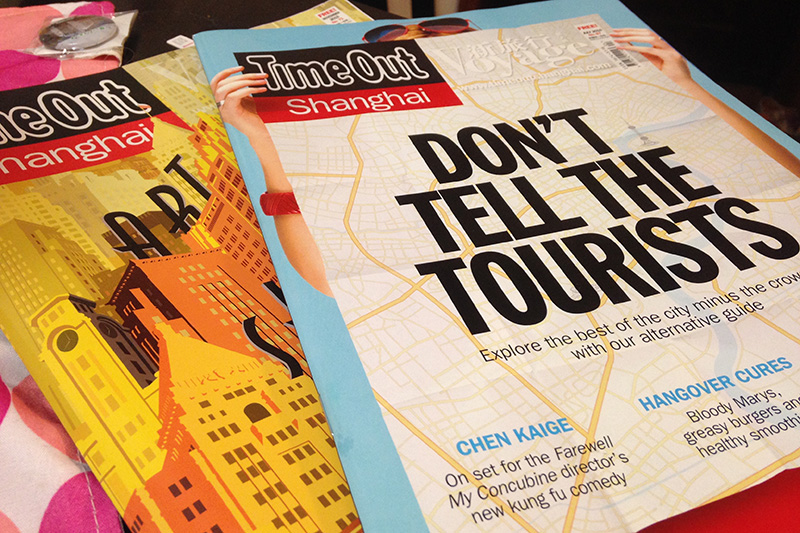 Stack of English-language magazines about Shanghai