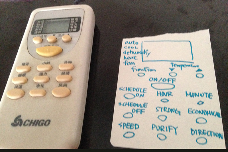 Air conditioner remote with English translations taped beside the buttons